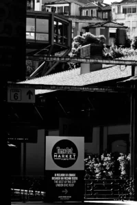 Black and white photo of Time out market sign with layered pedestrian movement (Mustvalge foto Time out market turusildist ja kihilisest liikumisest)