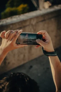 Hands holding smartphone, capturing city view in natural light (Käed pildistavad linnavaadet mobiiltelefoniga loomulikus valguses)