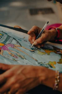 Hand writing on colorful illustration with pen, detailed close-up (Käsi kirjutab pastakaga värvilisel illustratsioonil, detailne lähivaade)