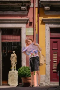 Woman standing in front of a red door, looking at a city map in Porto (Naine seisab punase ukse ees ja uurib kaarti Porto linnas)