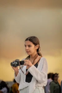 Young woman adjusting her camera during golden hour in Porto (Noor naine seab kaamerat kuldse valguse ajal Portos)