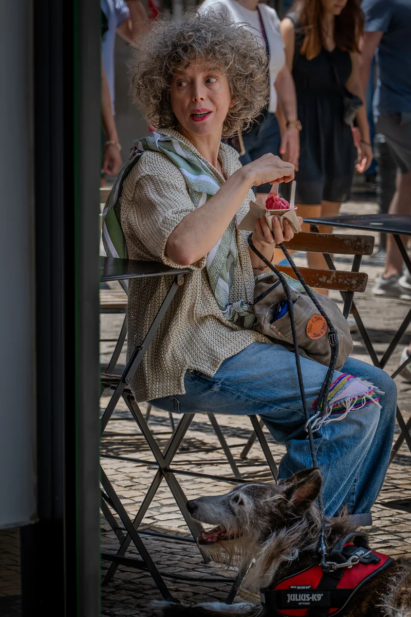 Woman sitting at a café in Porto with a small dog in her lap (Naine istub Porto kohvikus, süles väike koer)