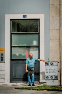 Man resting against a wall on a backstreet in Porto (Mees toetub vastu seina Porto kõrvaltänaval)