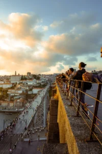People watching sunset over Porto from high city viewpoint (Inimesed naudivad vaadet Porto linnale päikeseloojangu ajal kõrgelt platvormilt)