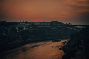 Bridge over Douro River in Porto during orange sunset glow (Sild Douro jõe kohal Portos oranžis päikeseloojangu valguses)