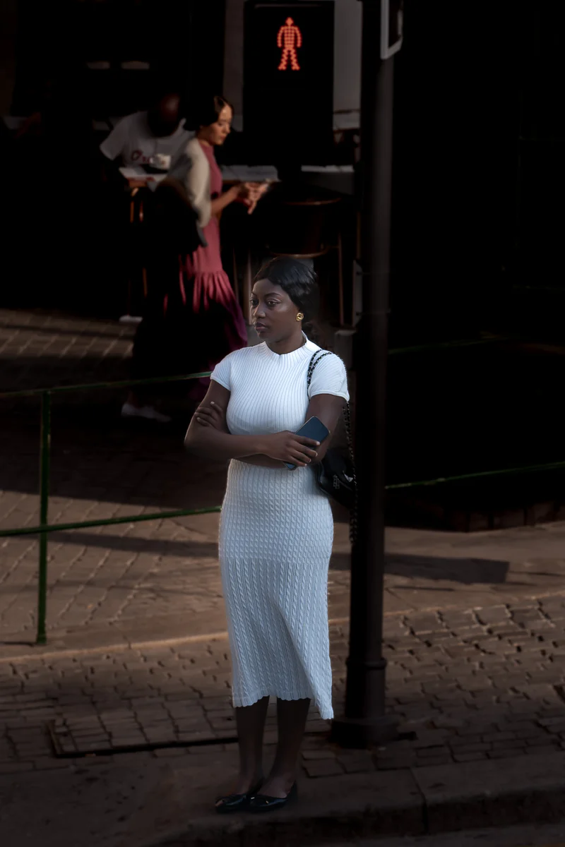 Woman in white dress standing on Porto street in late afternoon light (Naine valges kleidis seisab Porto tänaval hilisõhtu valguses)