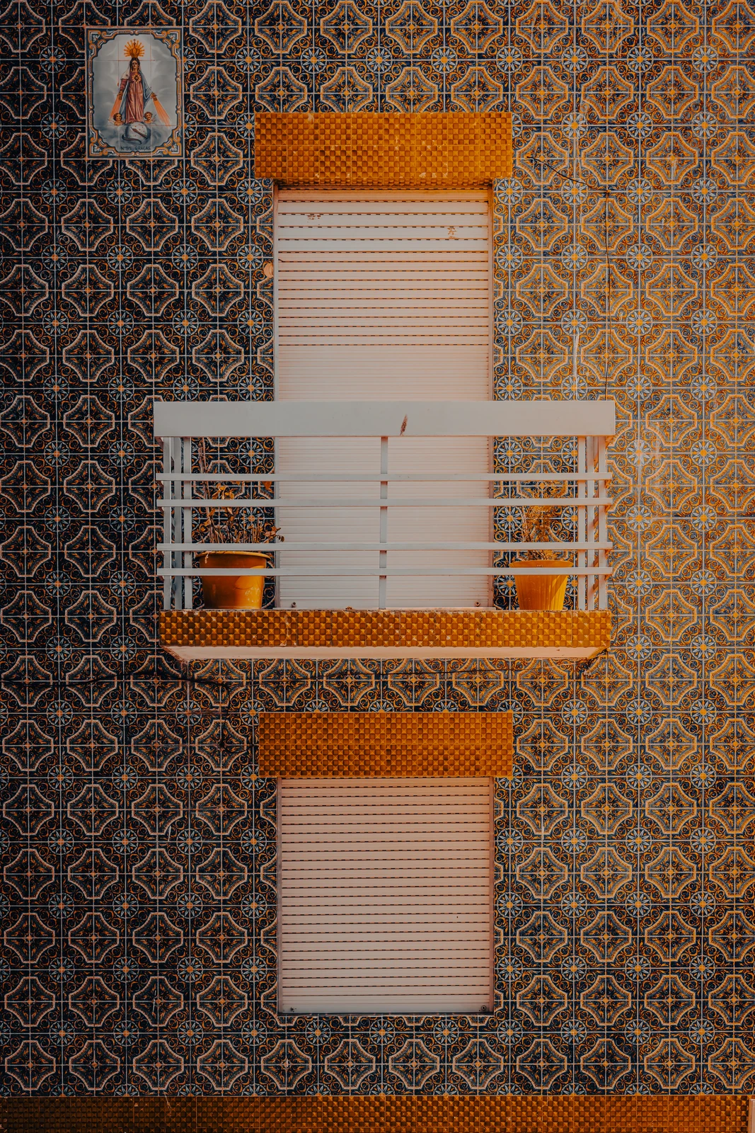 Symmetrical balcony on patterned tiled wall, viewed straight on (Arhitektuuriline muster, ideaalne graafilise minimalismi austajale)