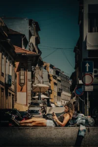 Woman in reading urban street lined with old buildings (Tüüpiline Portugali linnavaade, naine pikutab)