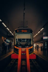 Subway train arriving at underground station with orange safety barrier (Porto metroo jaam, rong saabub platvormile)