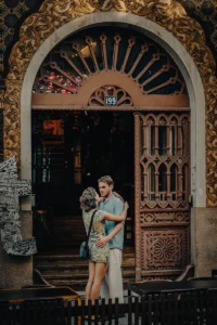 Mother with child standing in front of ornate Art Nouveau door (Ema lapsega seisab kaunistatud Art Nouveau ukse ees)