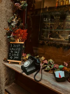 Vintage telephone with handwritten “I just called to say I love you” sign in Porto storefront (Retro telefon ja käsitsi kirjutatud silt poeaknal Portos)