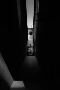 Narrow alley in black and white, dramatic light piercing the darkness (Monokroomne intensiivsus, tugeva tundefooniga)