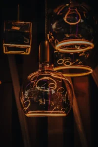 Neon-lit café interior with glowing outlines around glass teapots (Soe, intiimne valgus – urbanistlik elegants)