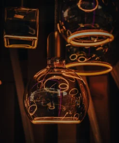 Neon-lit café interior with glowing outlines around glass teapots (Soe, intiimne valgus – urbanistlik elegants)