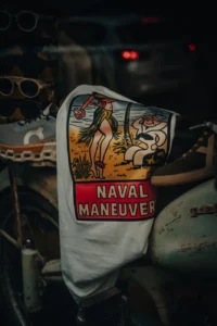 Close-up of a vintage jacket with “Naval Maneuver” patch in a thrift store (Stilistiline nostalgia, detailselt jäädvustatud)