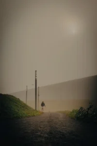 Person walking in the mist near a large minimalist building (Üksindus ja arhitektuuri vaikus kooskõlas)