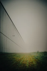 Industrial building facade disappearing into morning fog (Geomeetriline, vaikne – piir ruumi ja taju vahel) ERM