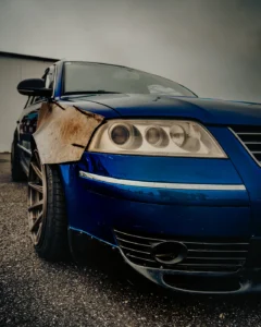 Blue car with rusted fender close-up at Augustfest 2025 (Kontrastselt jäädvustatud – uus ja kulunud koos)