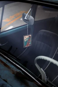 Vintage car interior with hanging card from rearview mirror at Augustfest 2025 (Detailportree, interjöörifookus)