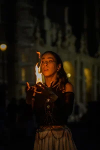 Fire performer Natalia raising flames in dramatic movement in Porto