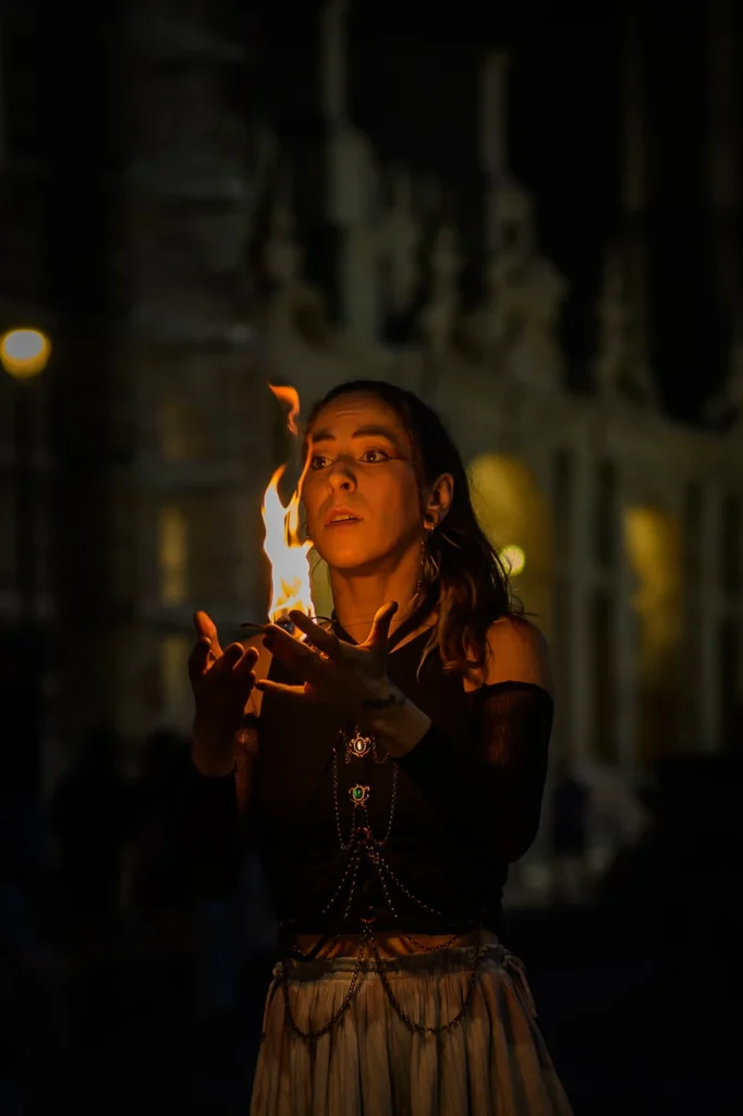 Fire performer Natalia raising flames in dramatic movement in Porto