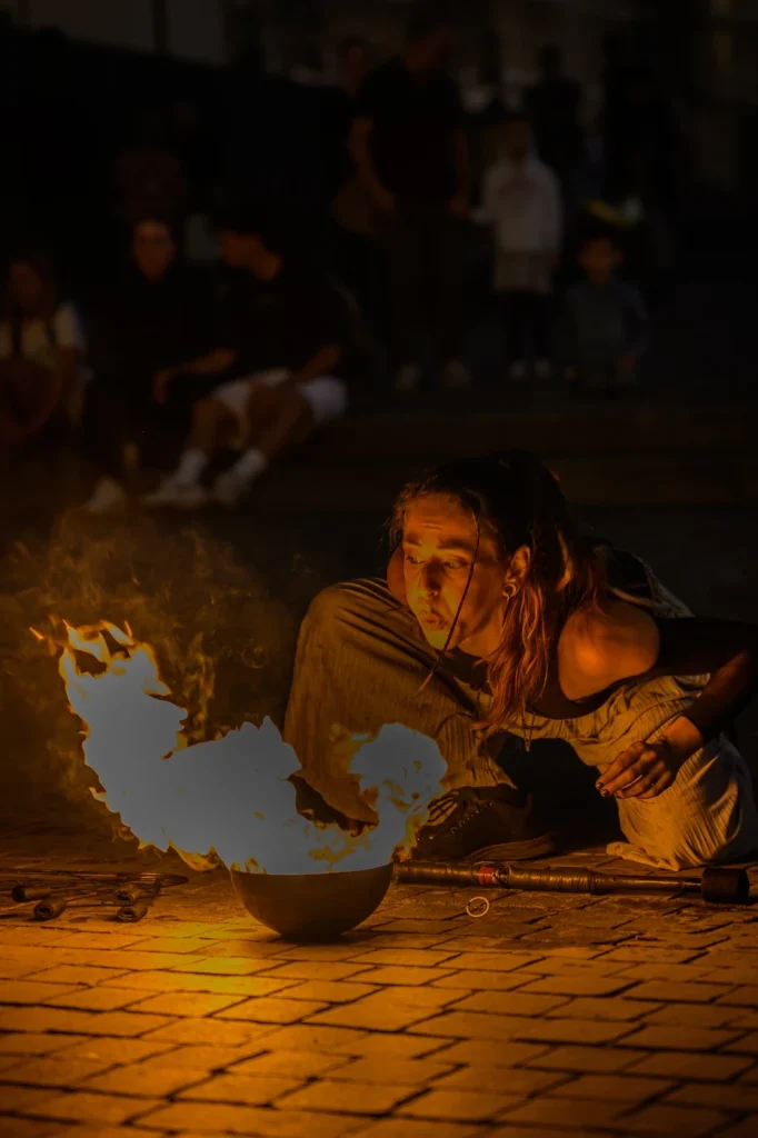 Street fire show with female dancer controlling fire poi, Porto Portugal