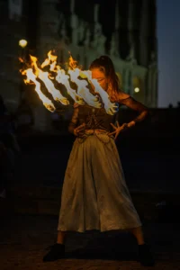 Fire dancing woman spinning multiple flames at night performance in Porto